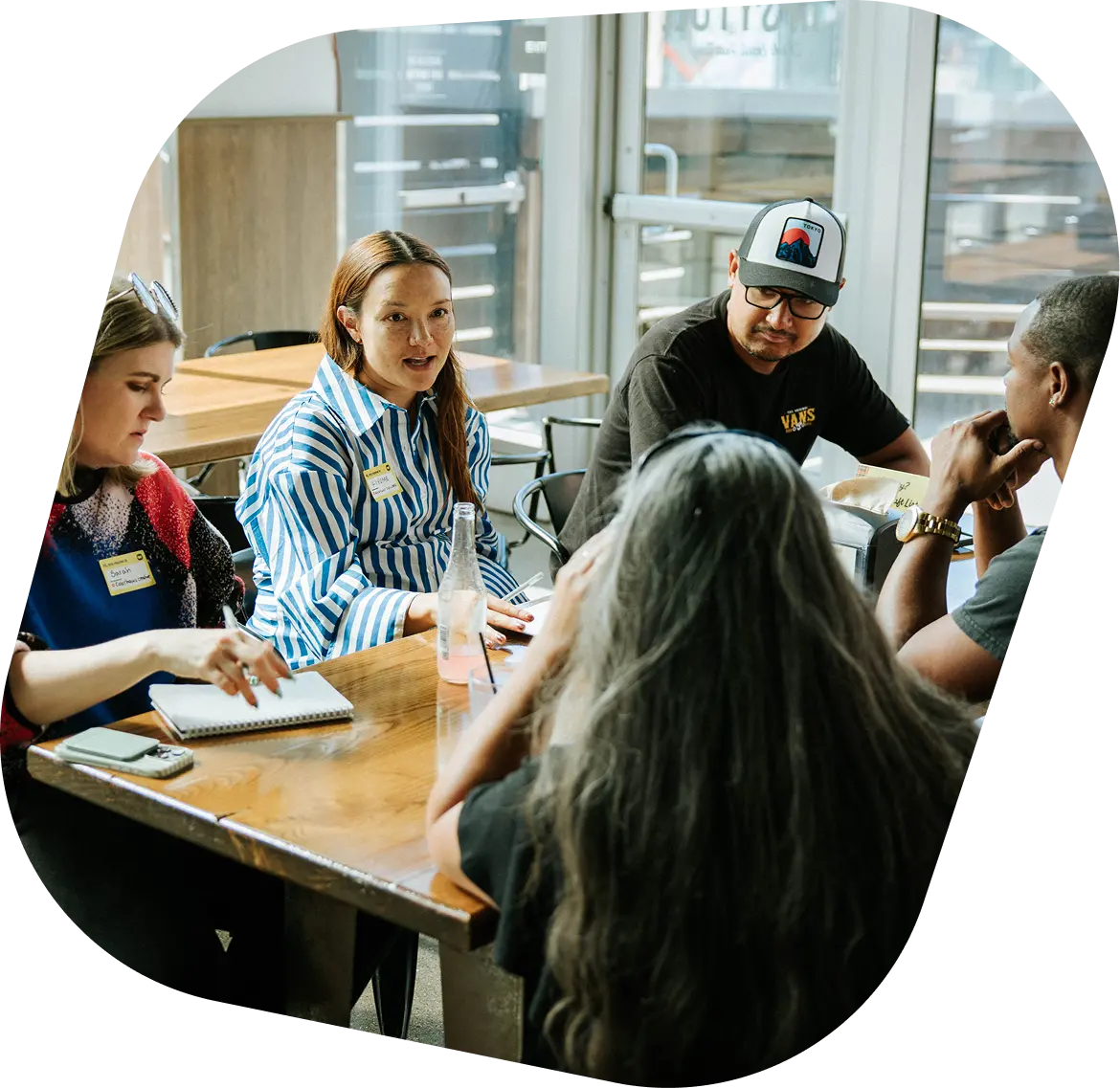 Vendeurs Whatnot discutant autour d'une table lors d'un meetup communautaire
